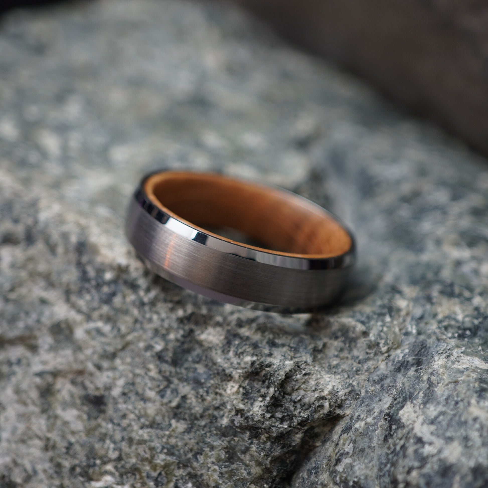 Matte black bevelled ring with barrel-wood interior, 6mm width, by Forge and Lumber.