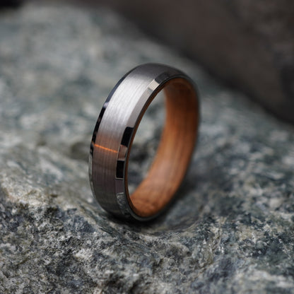 Beveled 6mm ring featuring a brushed stainless steel exterior and barrel wood interior by Forge and Lumber.