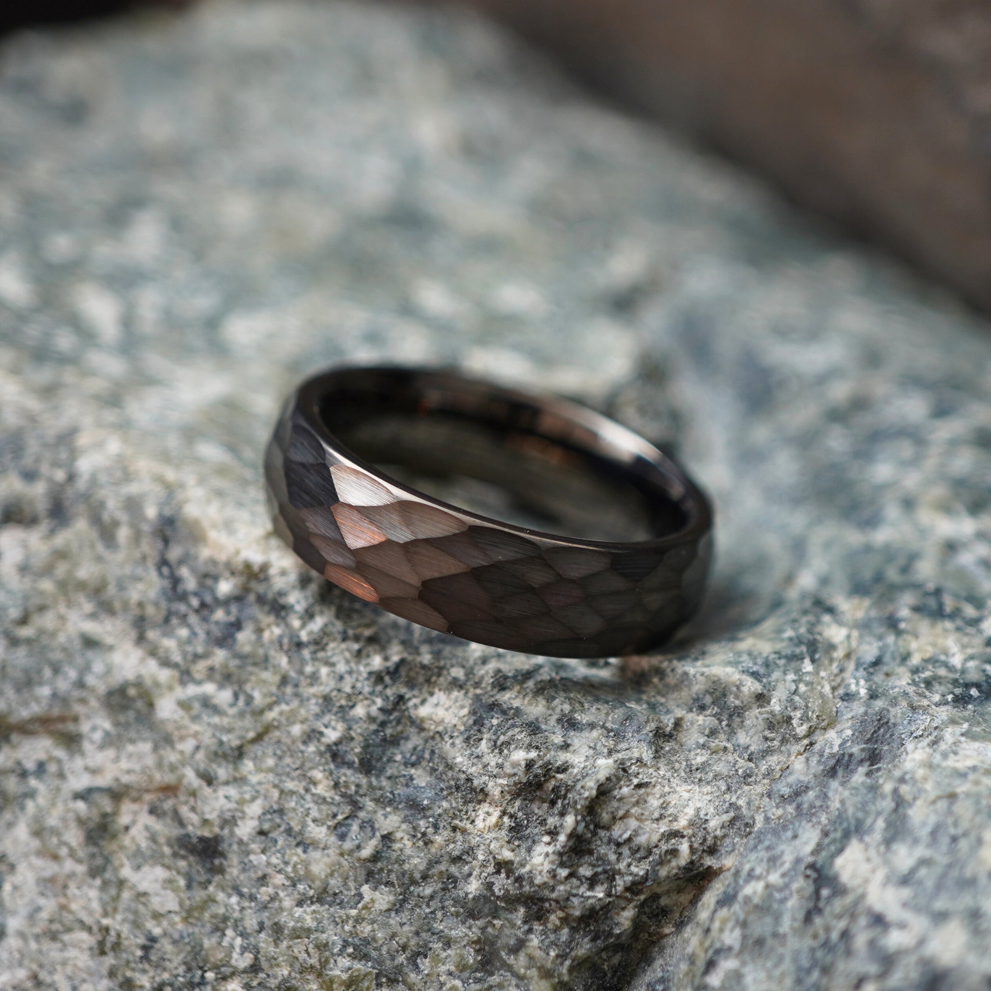 Black 6mm anvil-inspired ring with a textured finish by Forge and Lumber, set against stone background.