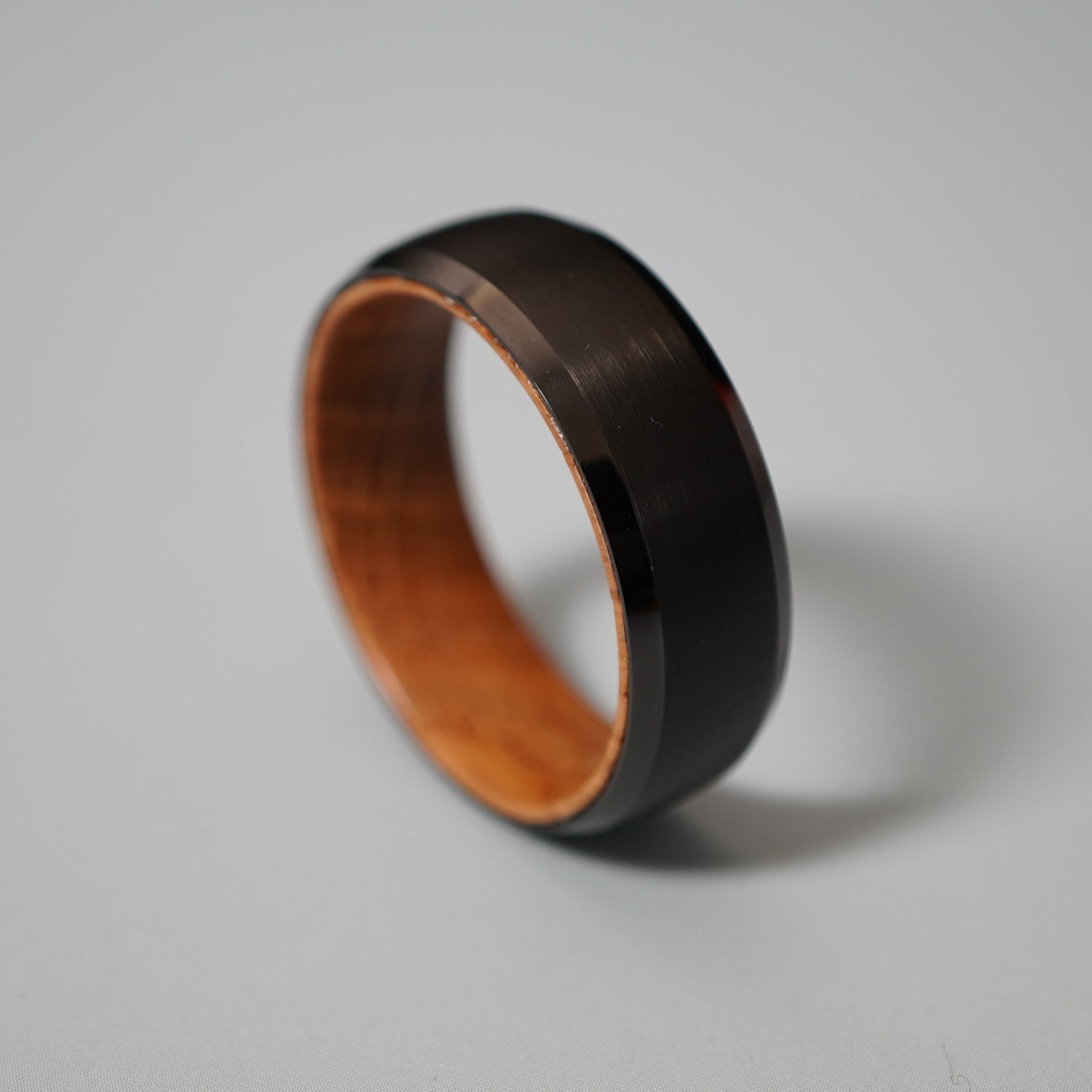 Black wooden ring with a polished exterior and natural wood interior.