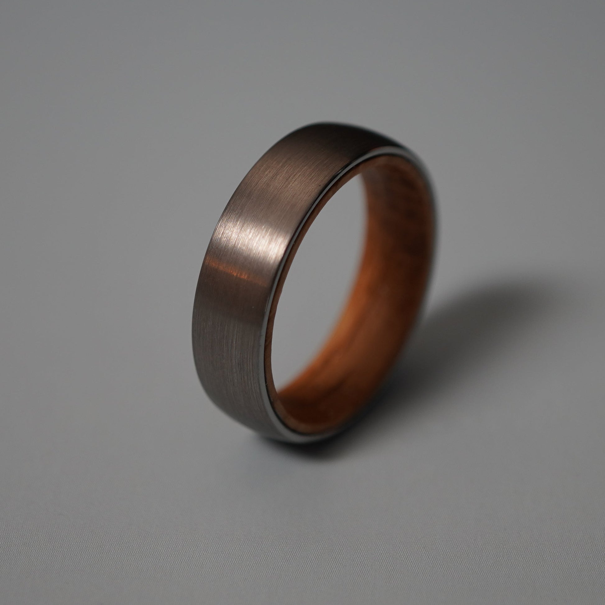 Black ceramic band ring with wooden interior by Forge and Lumber, 6mm width.