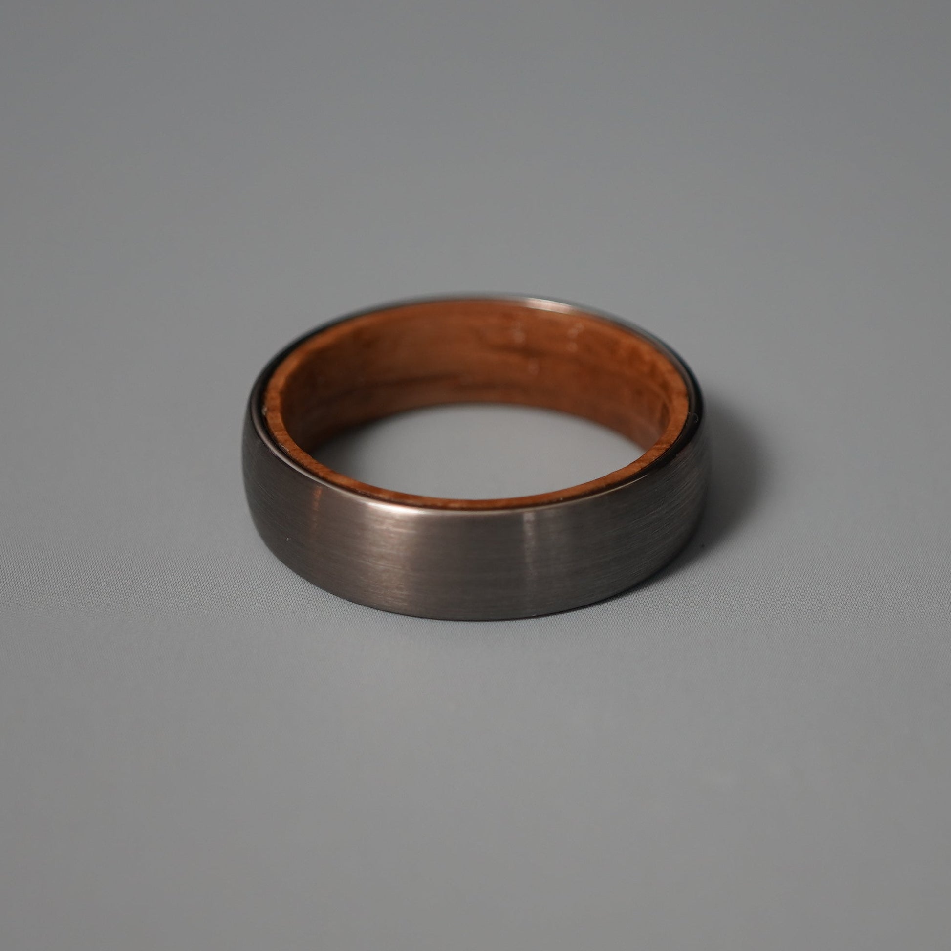 Black band ring with a brushed finish and wooden interior by Forge and Lumber.
