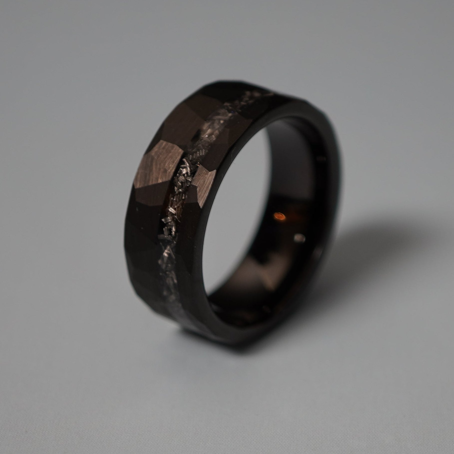 Black durable ring with a faceted design and textured band by Forge and Lumber, available in sizes UK M, N, O.