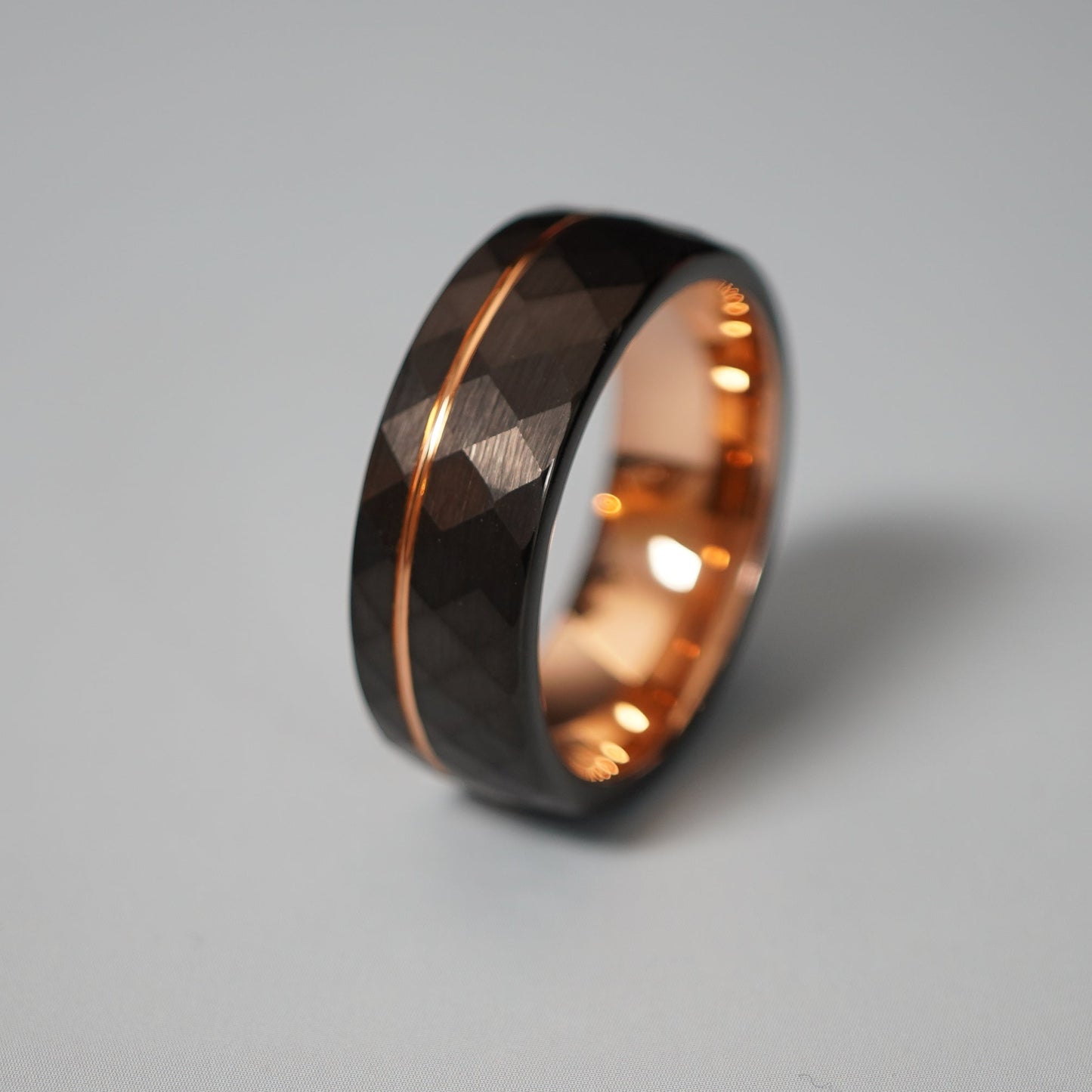 Black active lifestyle ring with 8mm width, featuring a faceted design and rose gold accents by Forge and Lumber.