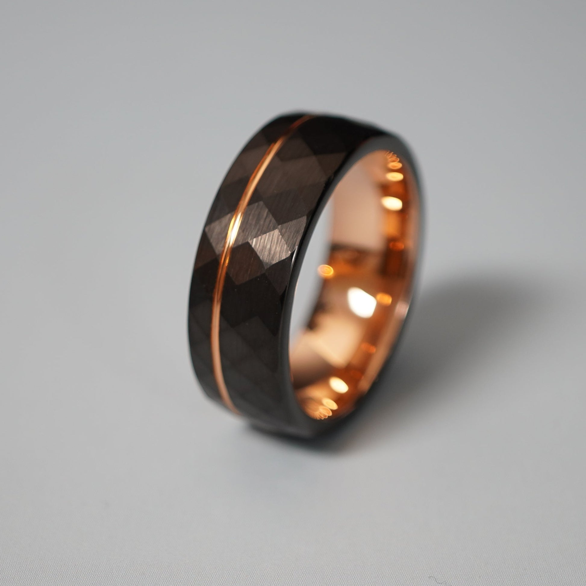 Black active lifestyle ring with 8mm width, featuring a faceted design and rose gold accents by Forge and Lumber.