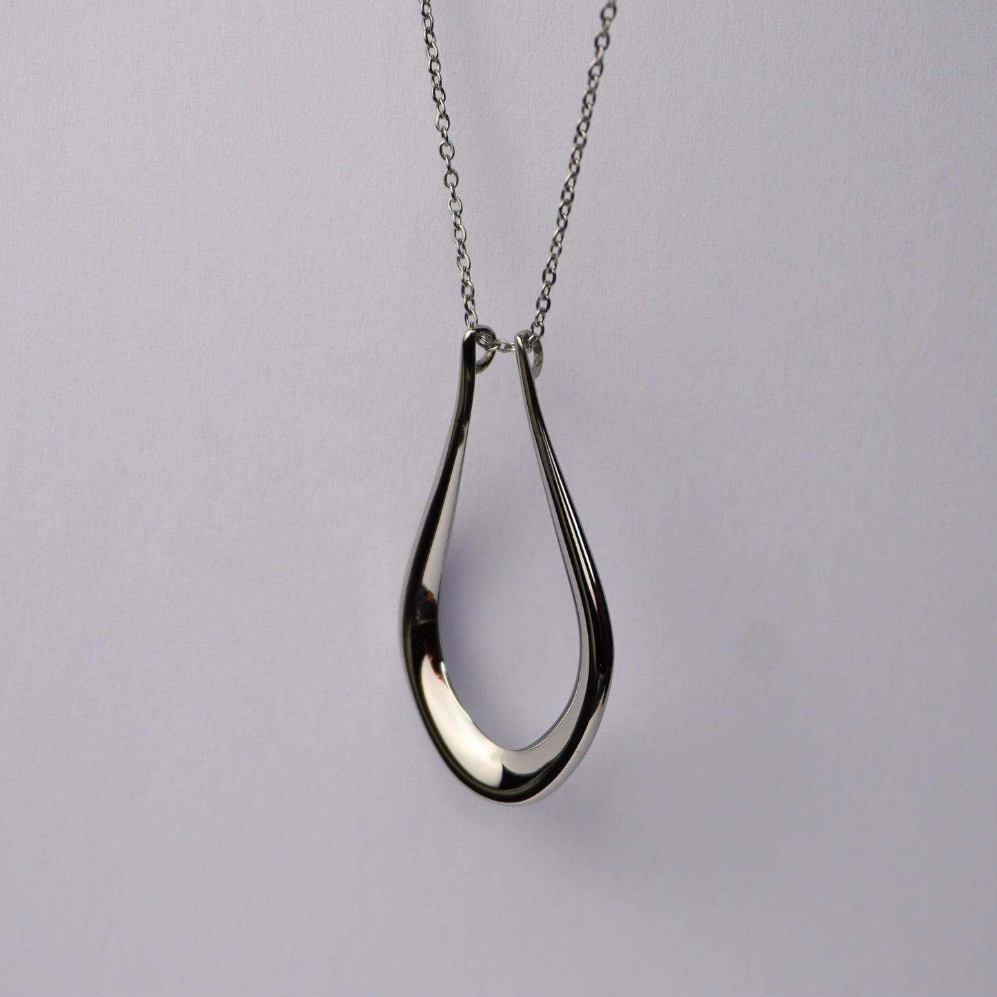Silver teardrop pendant necklace on a delicate chain.