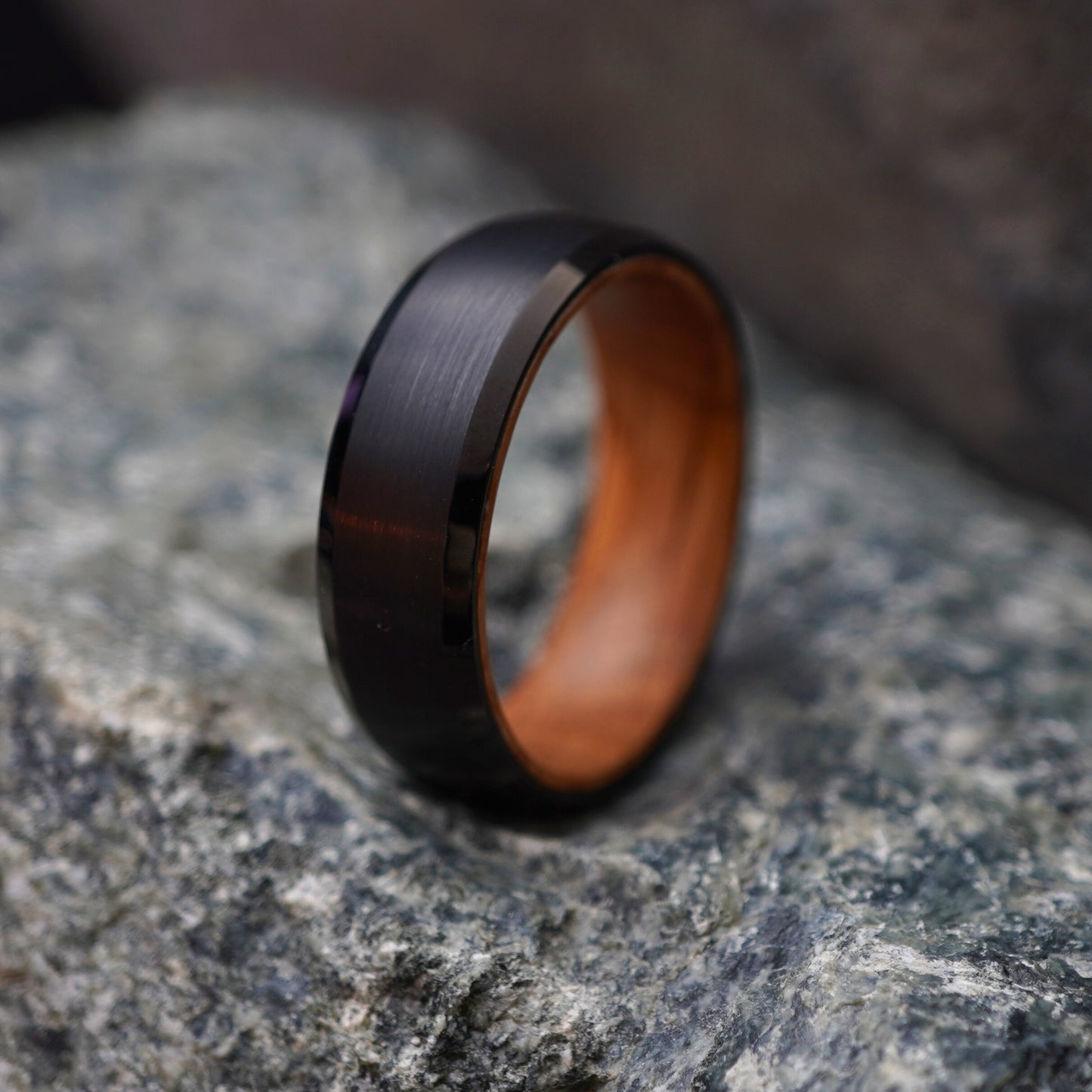 Black beveled-edge ring with barrel-wood interior by Forge and Lumber, 8mm width.