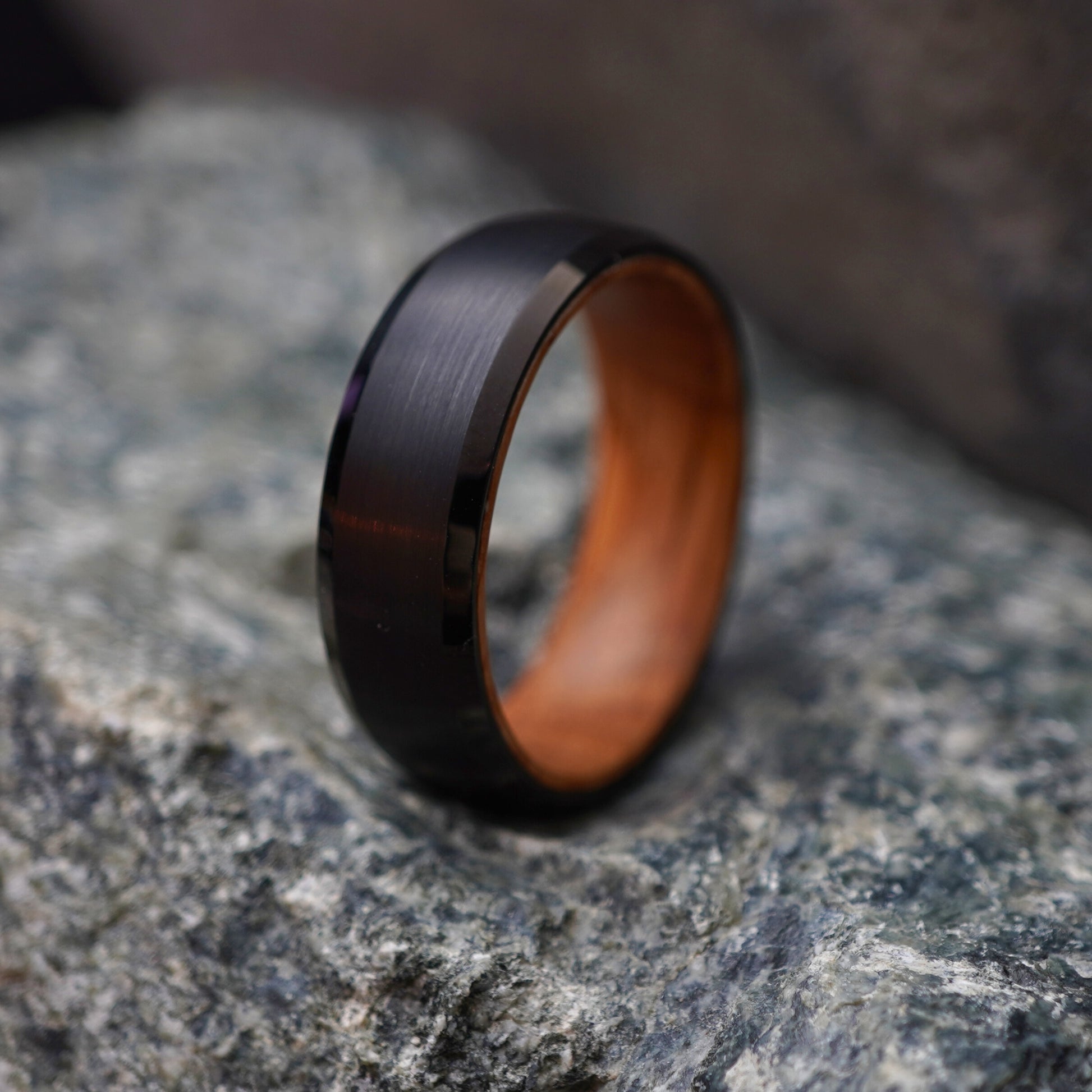Black beveled-edge ring with barrel-wood interior by Forge and Lumber, 8mm width.