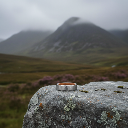 Silver comfort-fit ring with barrel-inspired design by Forge and Lumber, set against a misty mountain landscape.
