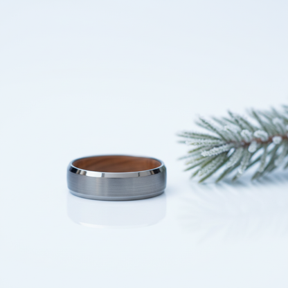 6mm tungsten ring by Forge and Lumber with a brushed finish and polished edge, placed next to a pine sprig.